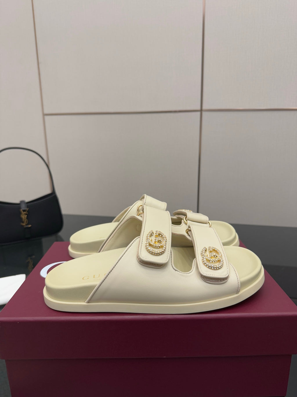 Gucci women's cream slide sandal with double straps and ornate gold-tone buckle