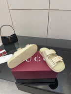 Gucci women's cream slide sandals with signature-pattern footbed and two strap buckles