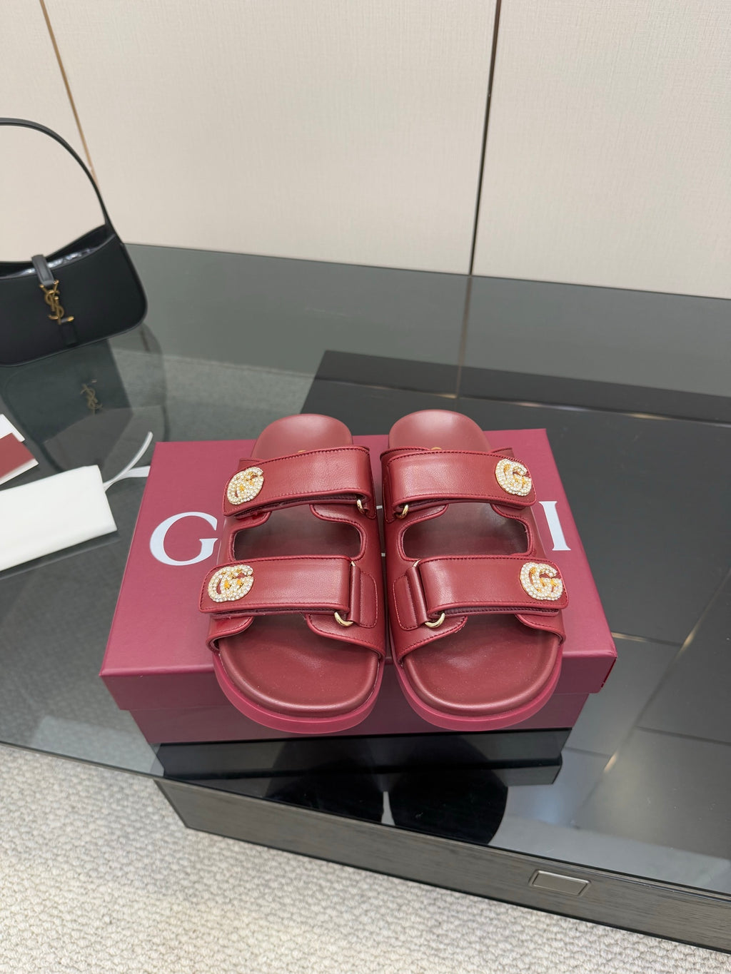 Red Gucci slide sandals with double straps and gold-tone logo buckles
