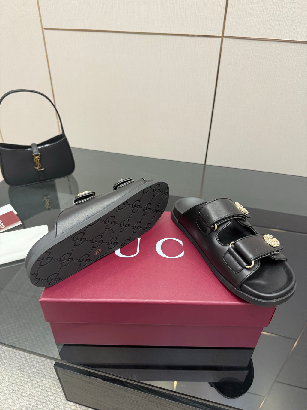 Gucci ladies black slide sandal with textured GG outsole pattern detail