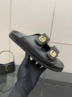Gucci ladies black slide sandal, close view of gold G buckle straps