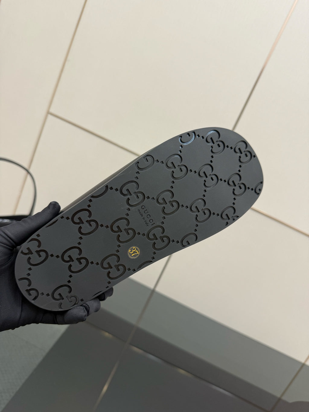 Gucci ladies black slide sandal outsole with dark GG monogram pattern