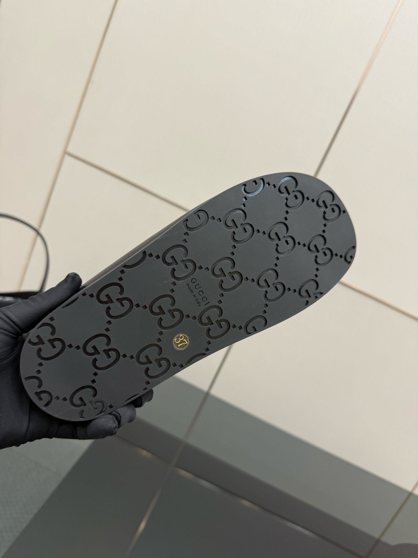 Gucci ladies black slide sandal outsole with dark GG monogram pattern