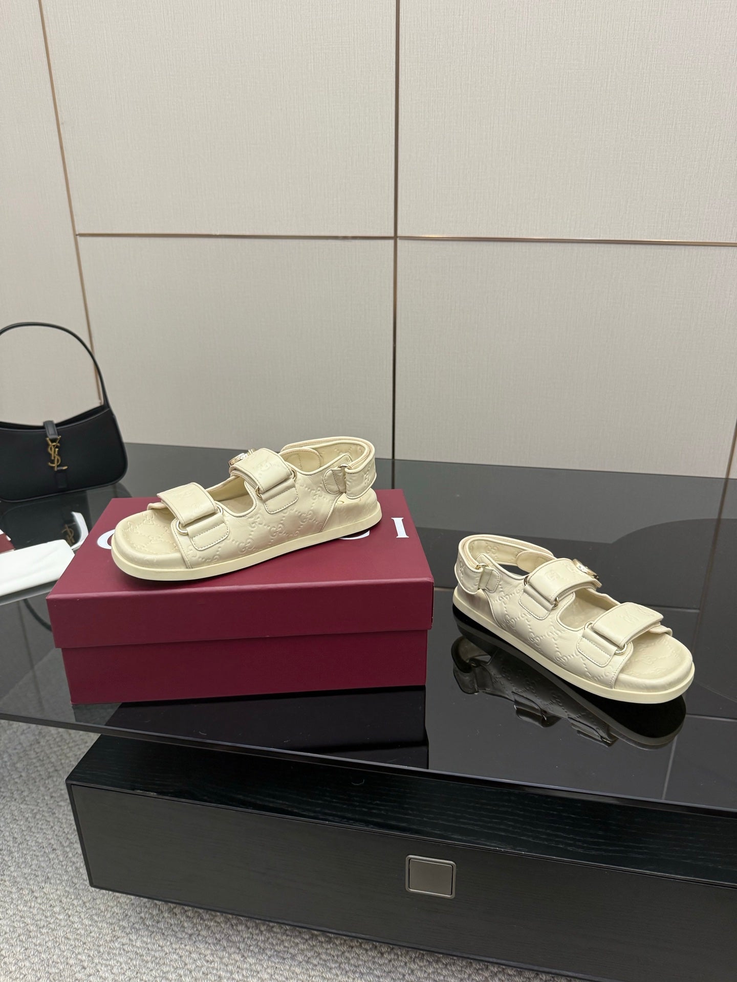 Cream slide sandals pair view; metal buckle straps on textured leather