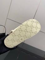 Cream slide sandal sole with embossed GG-style logo pattern