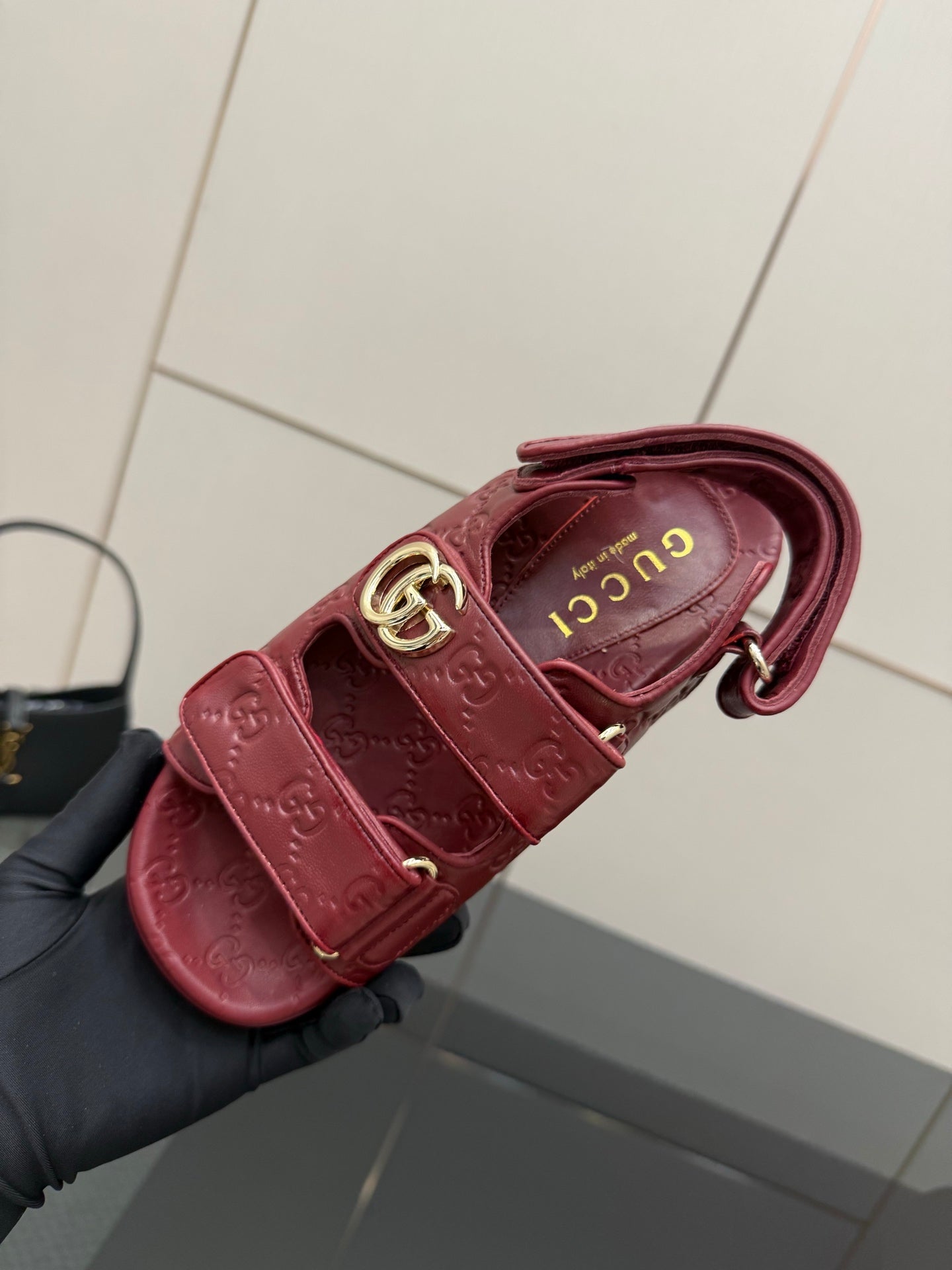 Red Gucci slide sandal with logo insole, close-up of buckle strap