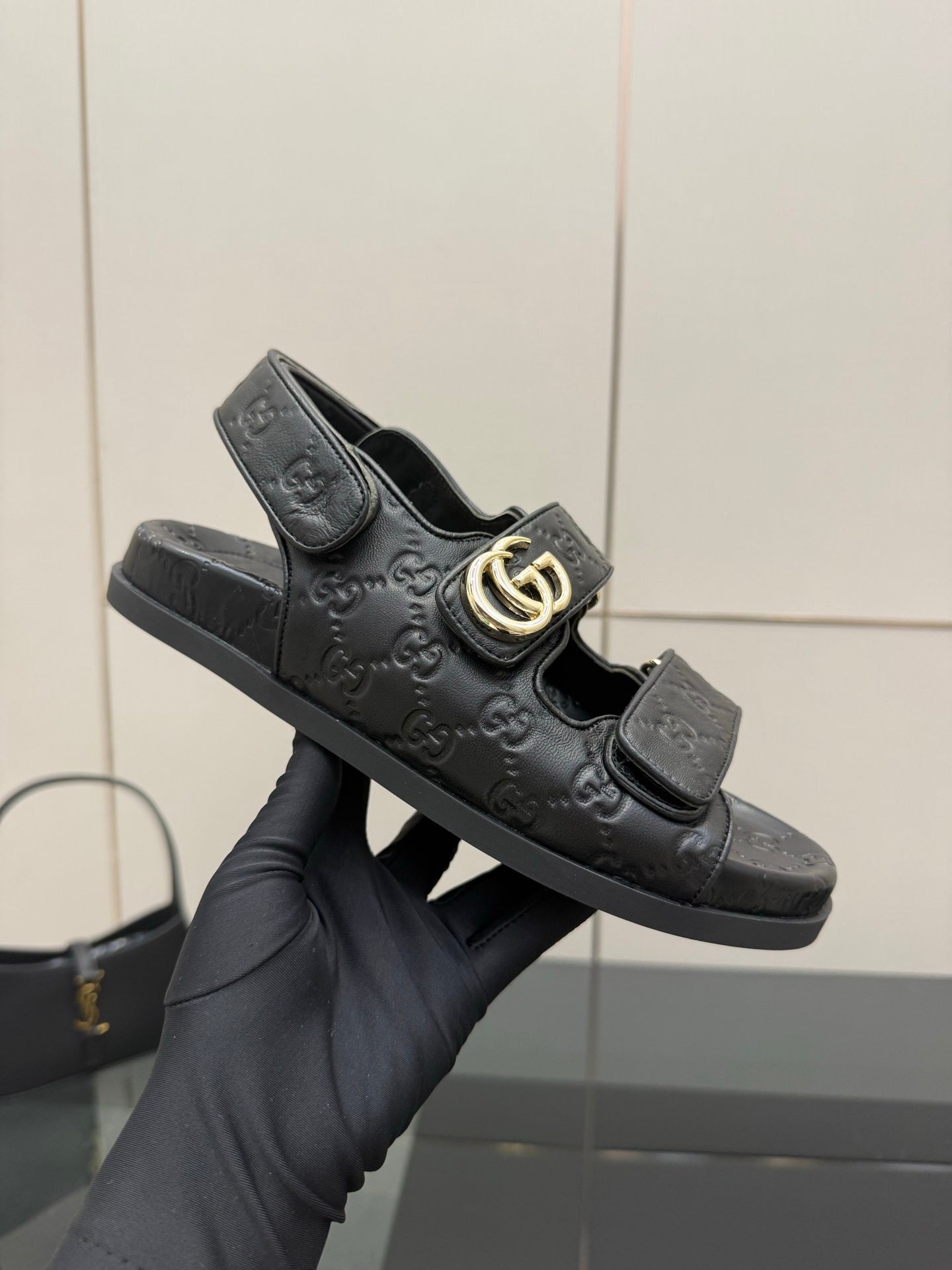 Gucci women's black slide sandals with logo pattern and gold double-G buckle