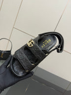 Gucci women's black slide sandals with gold double-G buckle and insole branding