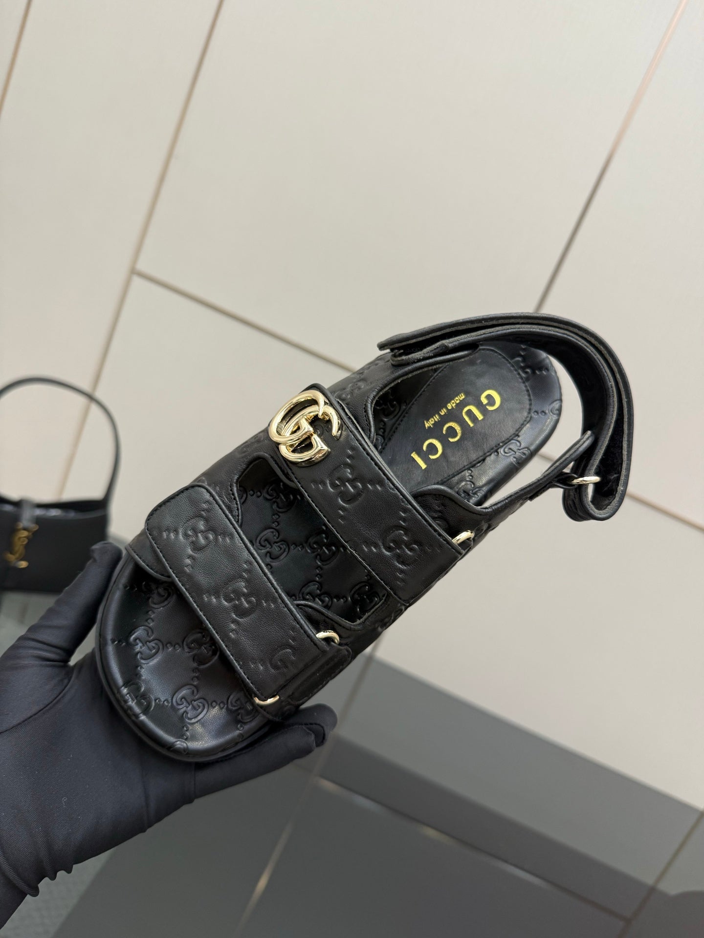 Gucci women's black slide sandals with gold double-G buckle and insole branding