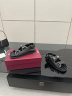 Gucci women's black sandals with gold-tone buckles, side profile view