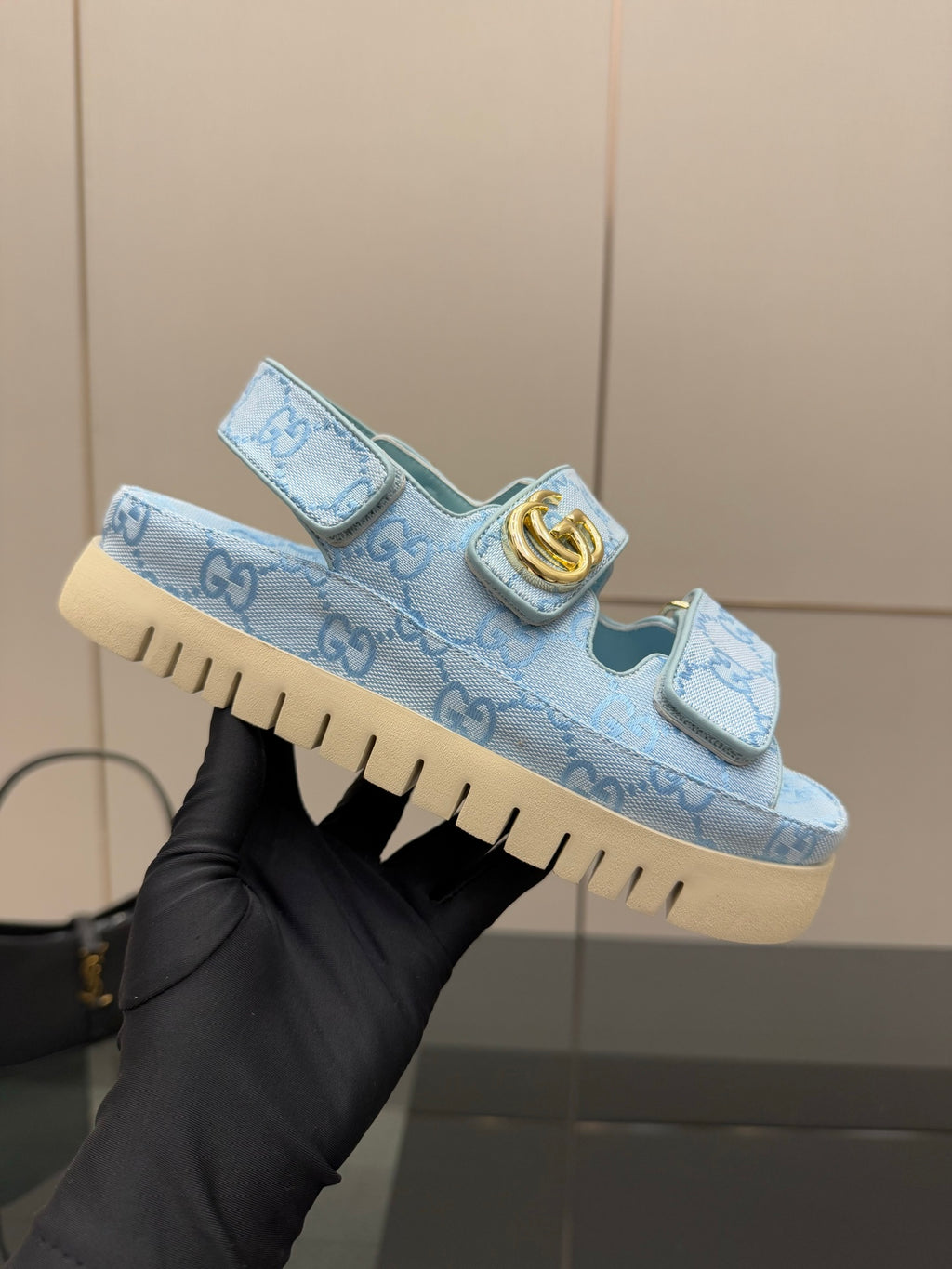 Gucci ladies light blue GG-pattern sneaker held up, gold buckle strap detail