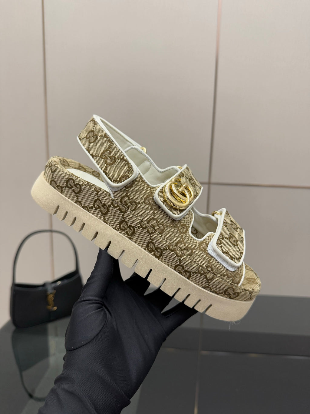 Gucci women’s sneakers held up: beige GG canvas with gold accent and white sole