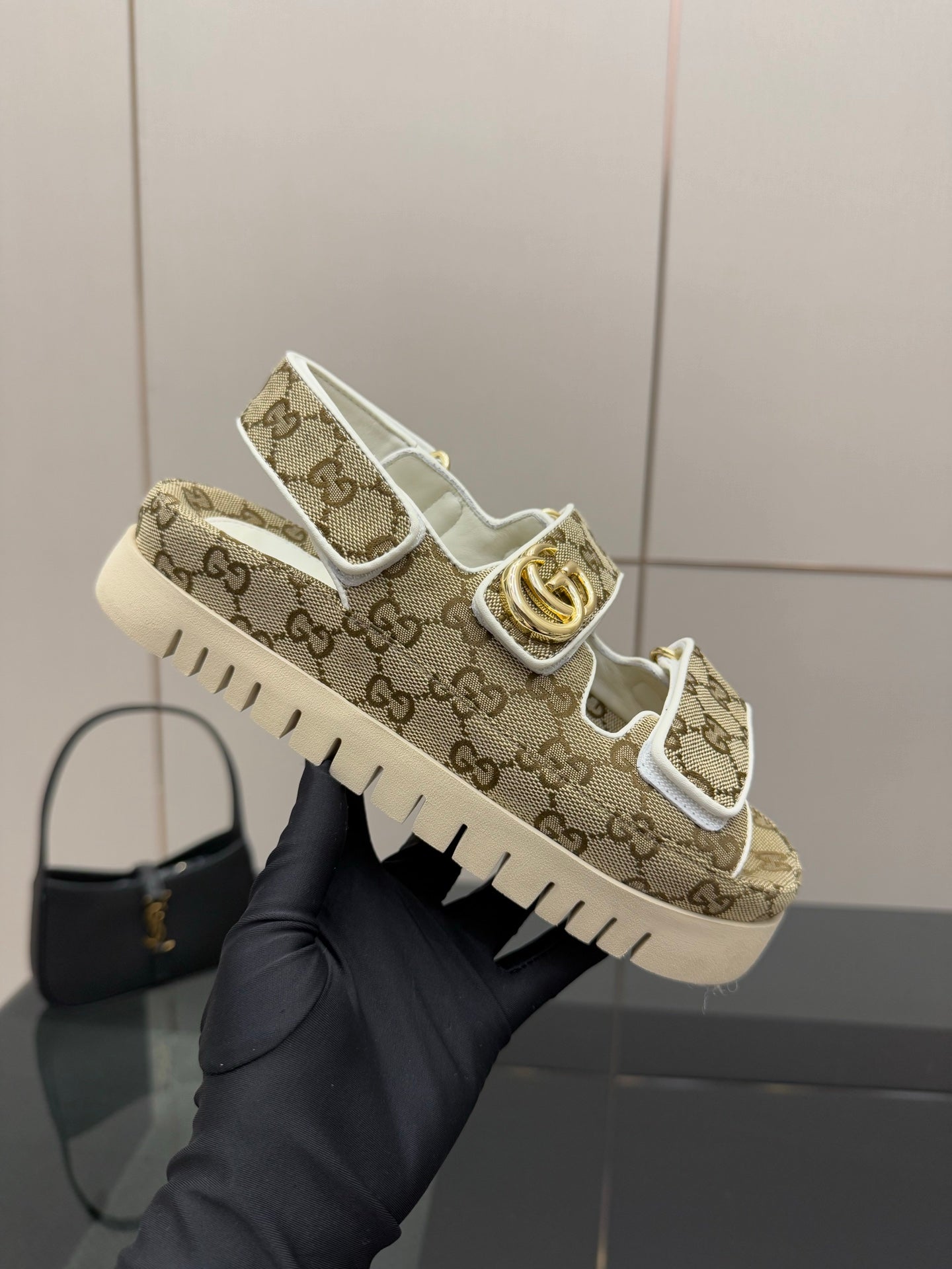 Gucci women’s sneakers held up: beige GG canvas with gold accent and white sole