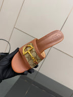 Women's Gucci tan mule sandal side view with logo-patterned strap and gold horsebit