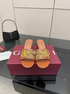 Women's Gucci mule sandals with tan patterned strap and gold horsebit detail