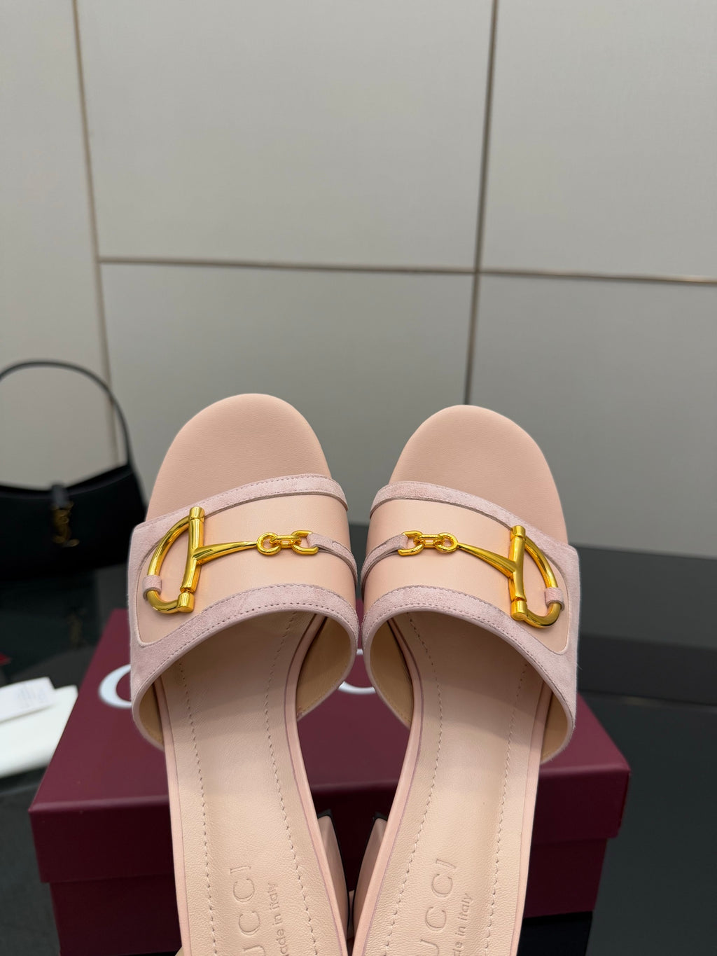 Gucci women’s mule slides, front view of light pink straps with gold buckle ornament