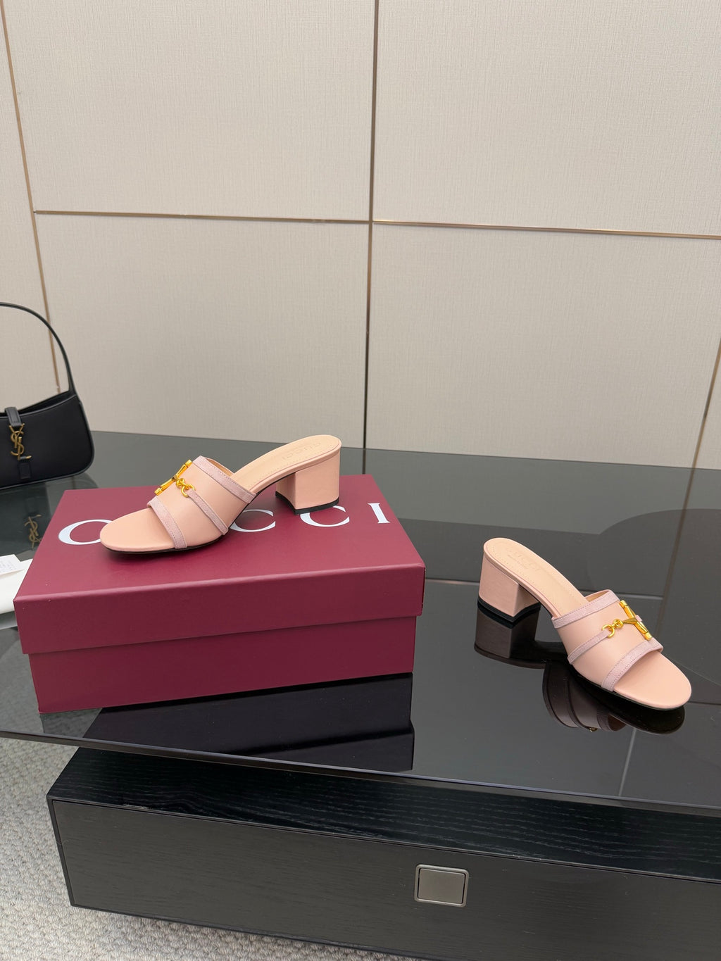 Gucci women’s slide mules, light pink with gold buckle, shown from side on display box