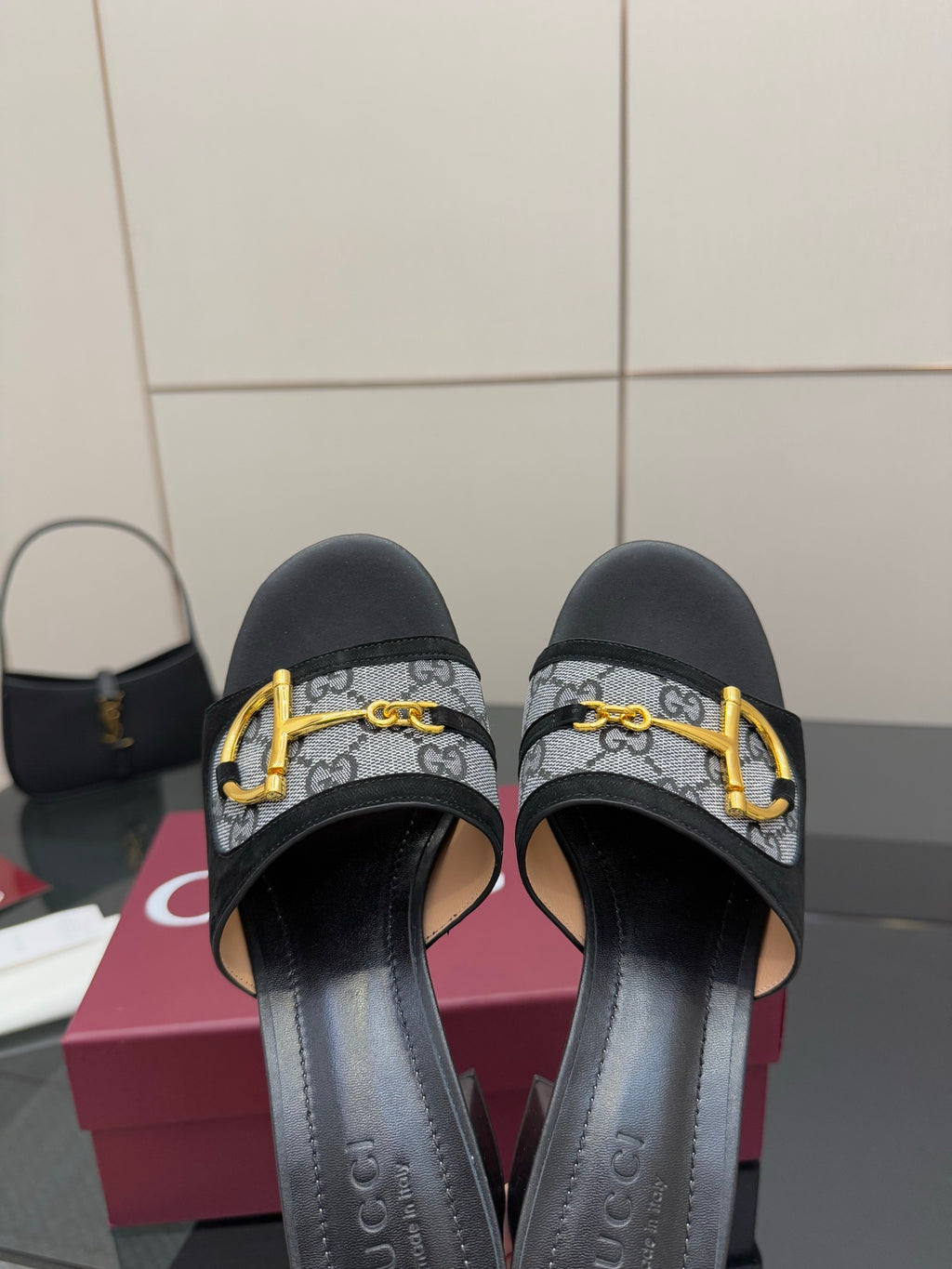 Black slides with GG-print straps and gold buckle, close-up front view