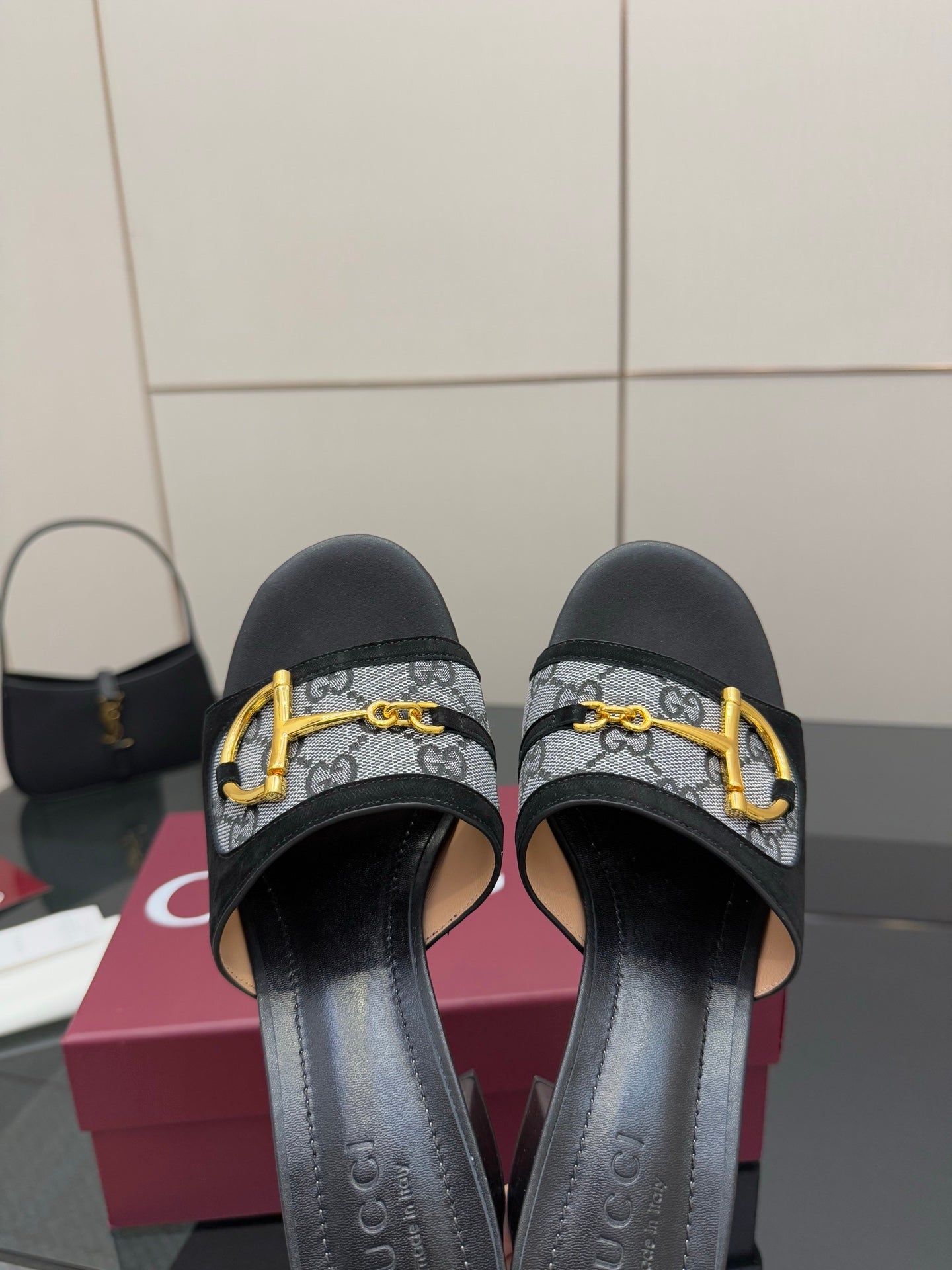 Black slides with GG-print straps and gold buckle, close-up front view