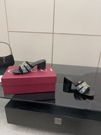 Black block-heel slides with GG-print strap and gold buckle, angled side view