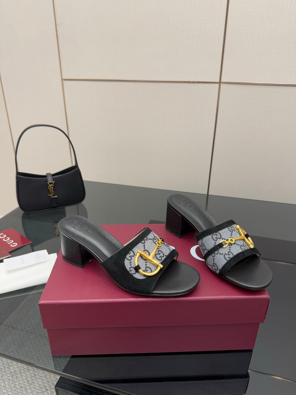 Black slide sandals with GG-print straps, gold buckle detail, block heel pair
