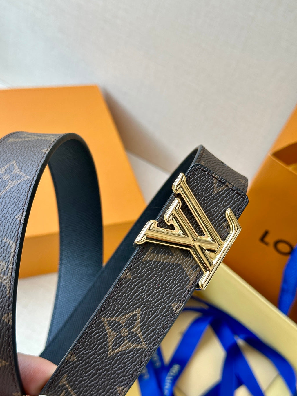 Brown monogram leather belt detail with gold-tone buckle and dark end hardware