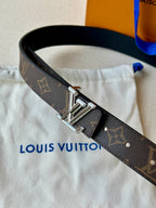 Brown monogram leather belt close-up with polished metal buckle and stitched end