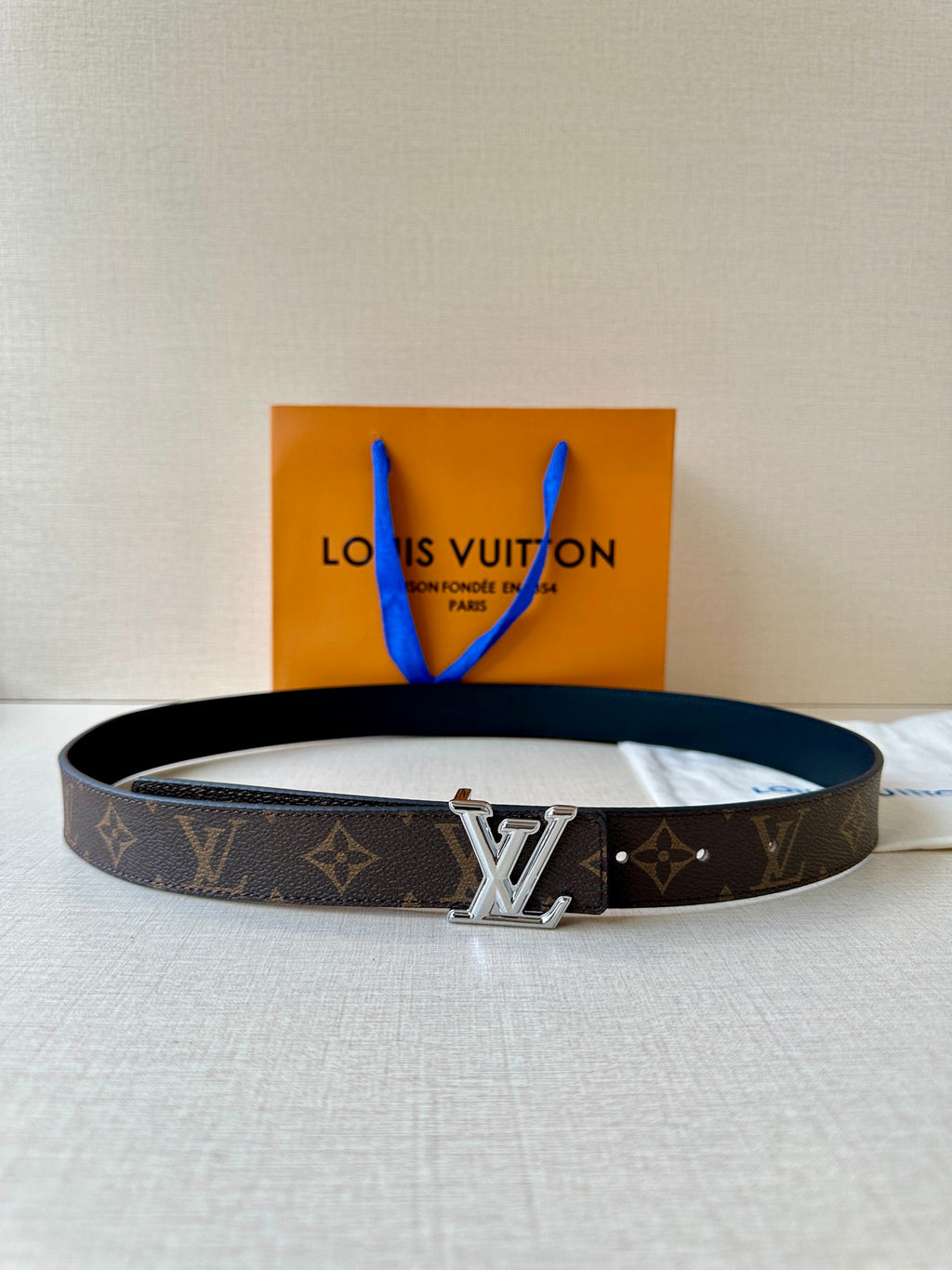 Brown monogram leather belt with gold-tone square buckle and dark adjustable holes