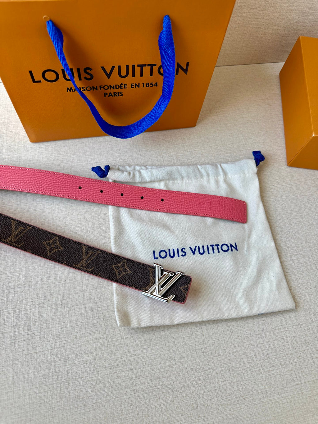 Pink leather belt strap with silver LV buckle on dark monogram belt, in pouch