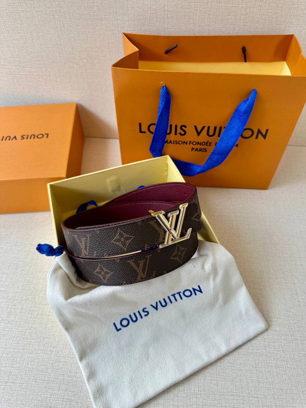 Louis Vuitton monogram belt with gold-tone LV buckle on burgundy strap
