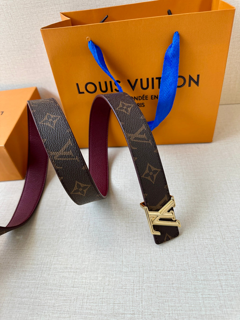 Louis Vuitton monogram belt with gold-tone buckle and burgundy inner edge