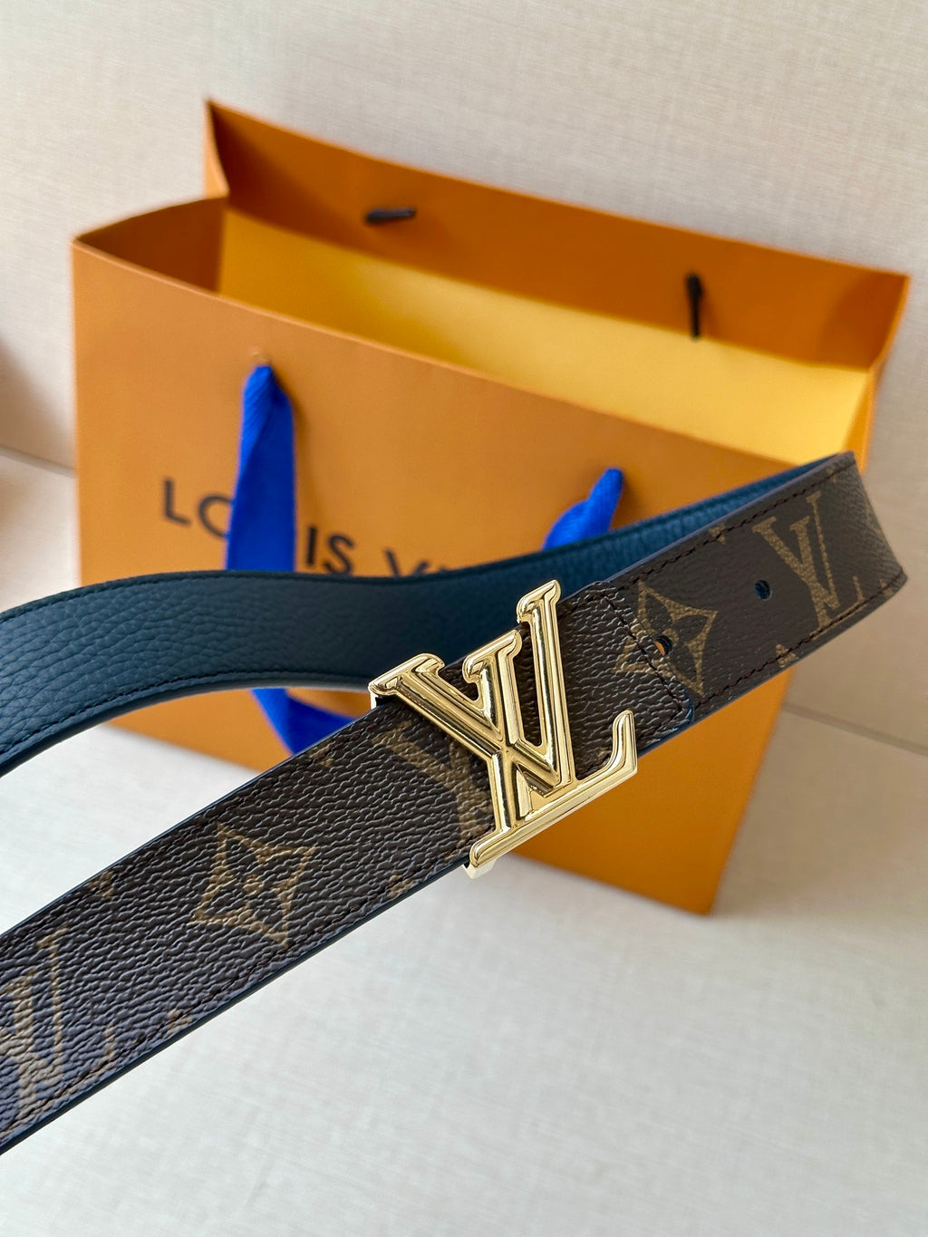 Monogram belt with gold LV buckle on dark textured leather strap