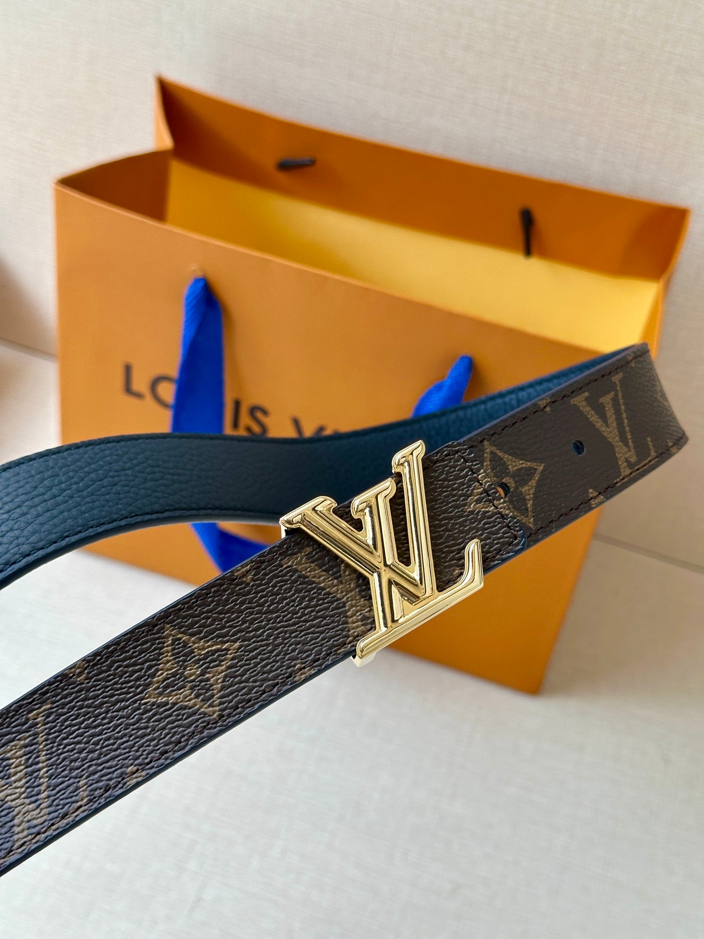 Monogram belt with gold LV buckle on dark textured leather strap