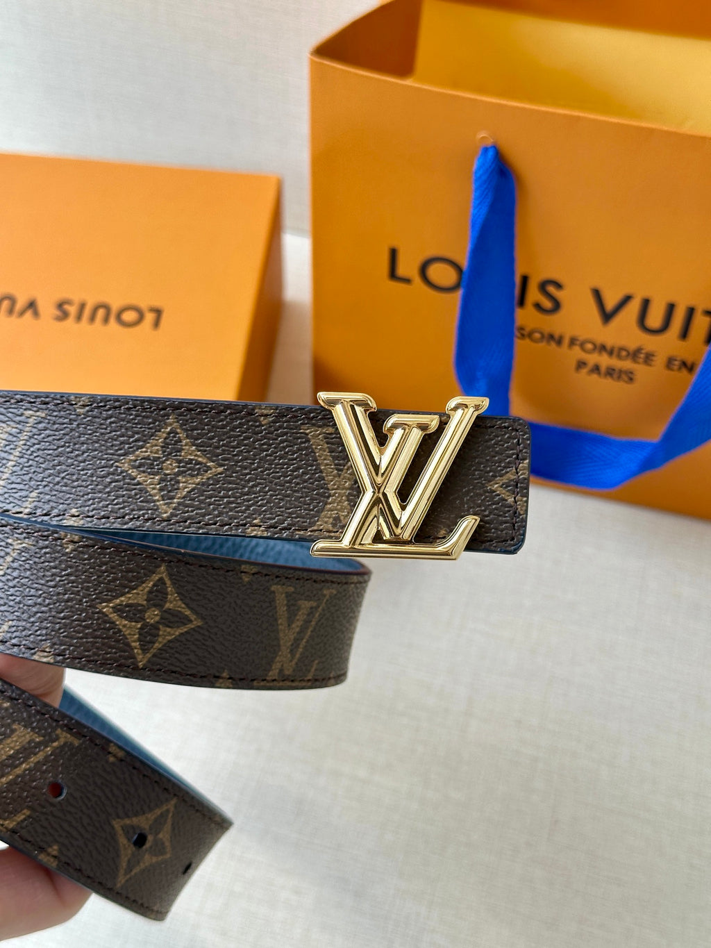 Monogram belt with gold LV buckle and dark patterned strap
