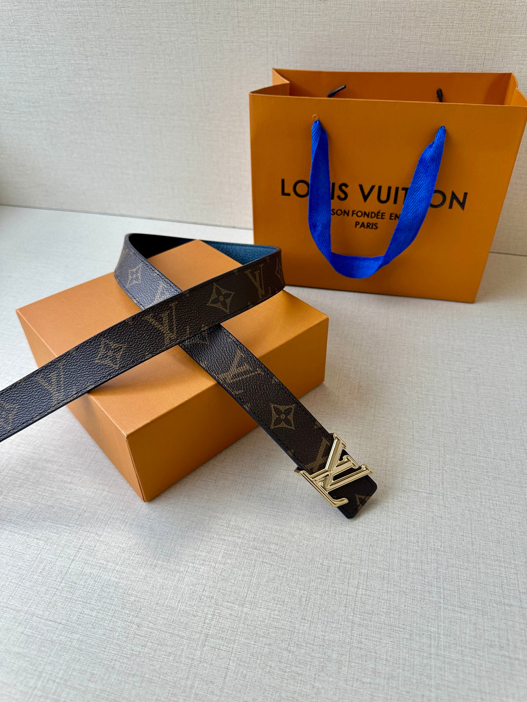 Monogram belt with gold LV buckle, dark strap shown laid out