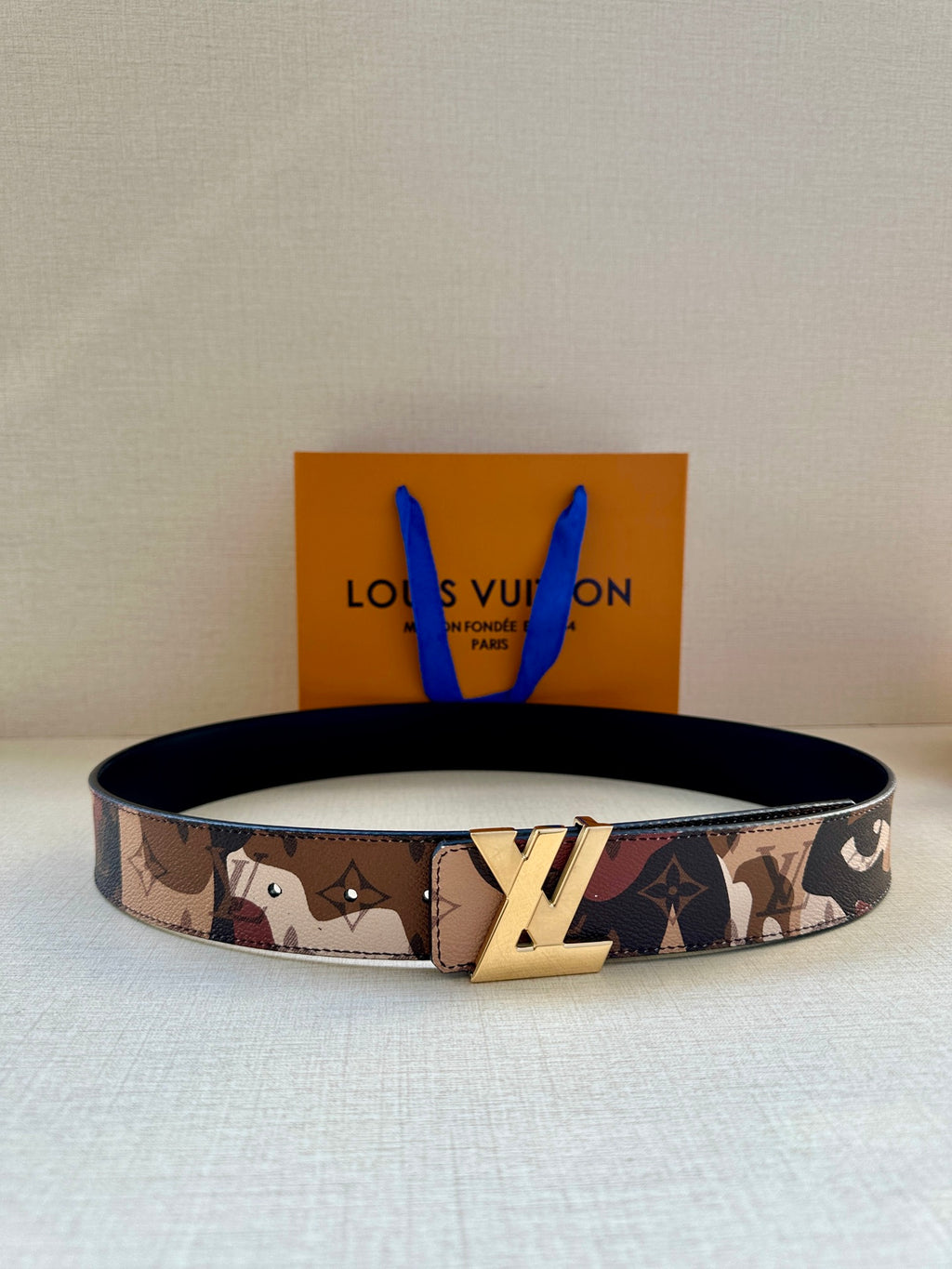 Monogram canvas belt with tan, brown, and navy pattern and gold-tone buckle
