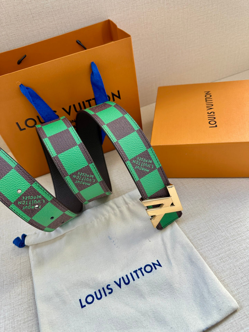 Louis Vuitton belt with green check webbing and gold-tone buckle, black leather backing