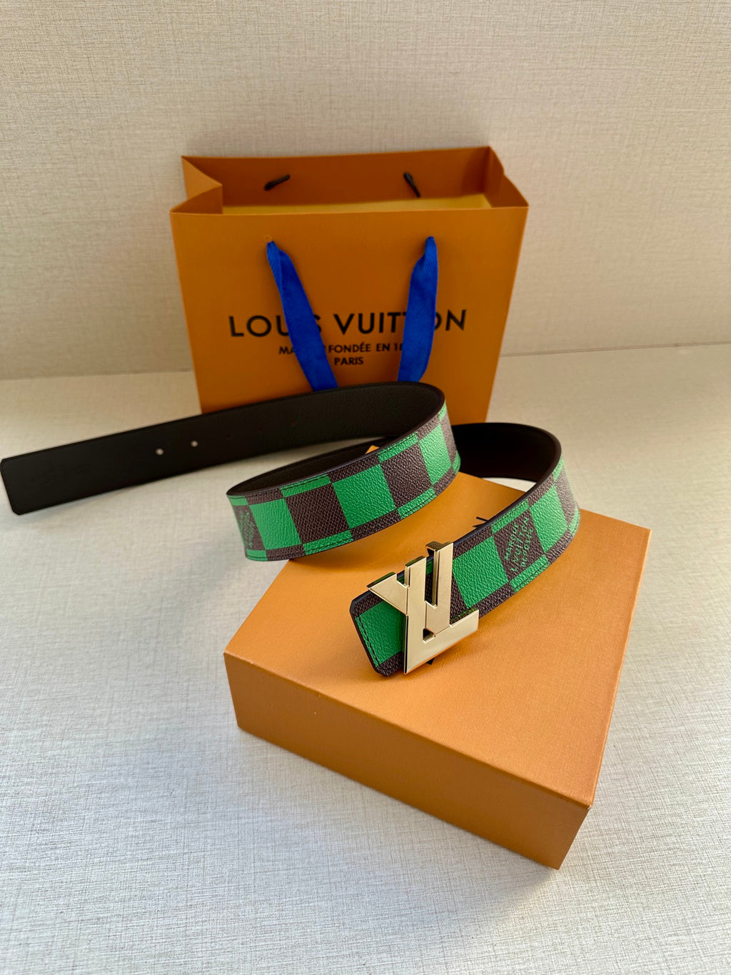 Louis Vuitton belt with black strap, green check pattern and gold-tone buckle