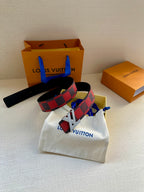 Louis Vuitton belt with checkered strap and gold buckle, laid on white pouch