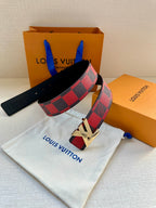 Louis Vuitton belt with checkered strap and gold buckle, resting on white pouch