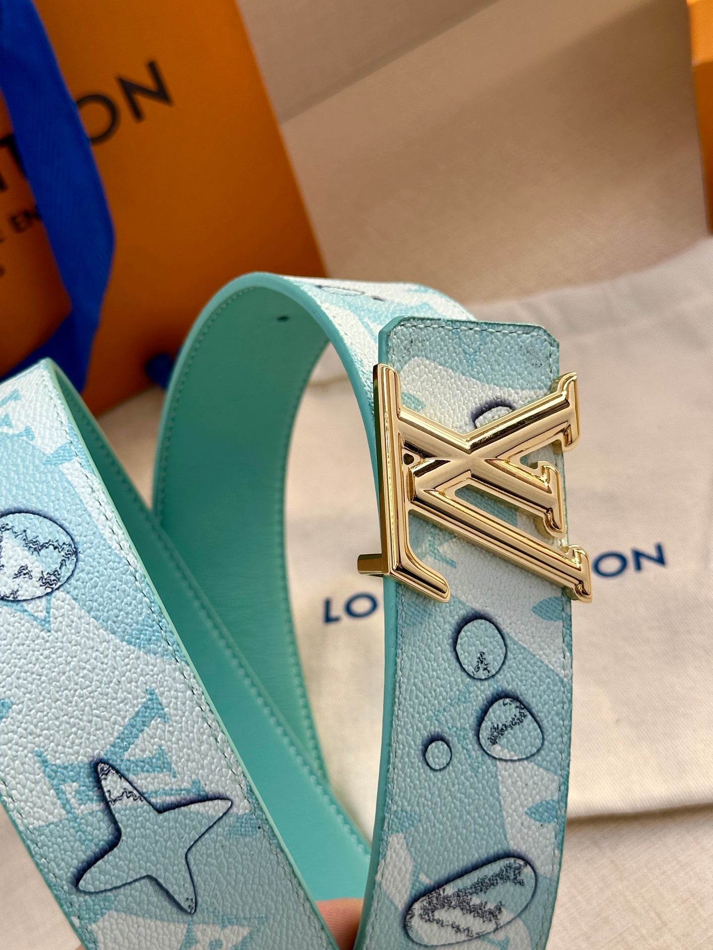 Turquoise Louis Vuitton belt with gold-tone LV buckle and stamped monogram motifs