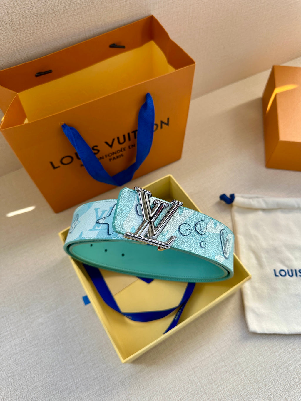Turquoise Louis Vuitton belt with gold-tone LV buckle and matching pouch