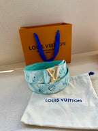 Turquoise Louis Vuitton belt with gold-tone LV buckle on fabric pouch