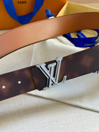 Dark brown leather belt with large silver-tone LV buckle and punched holes.