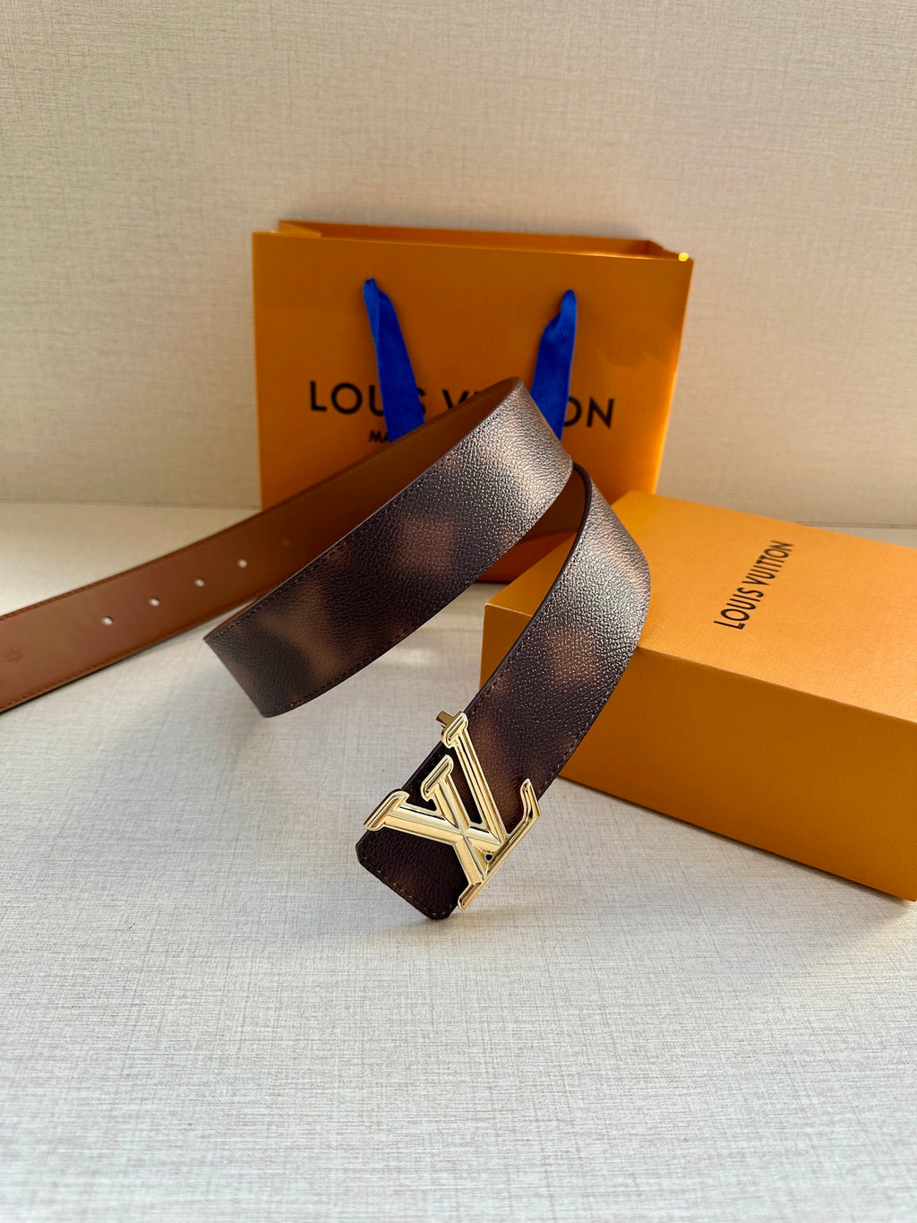 Dark brown leather belt with silver-tone LV buckle and pin-hole strap end.