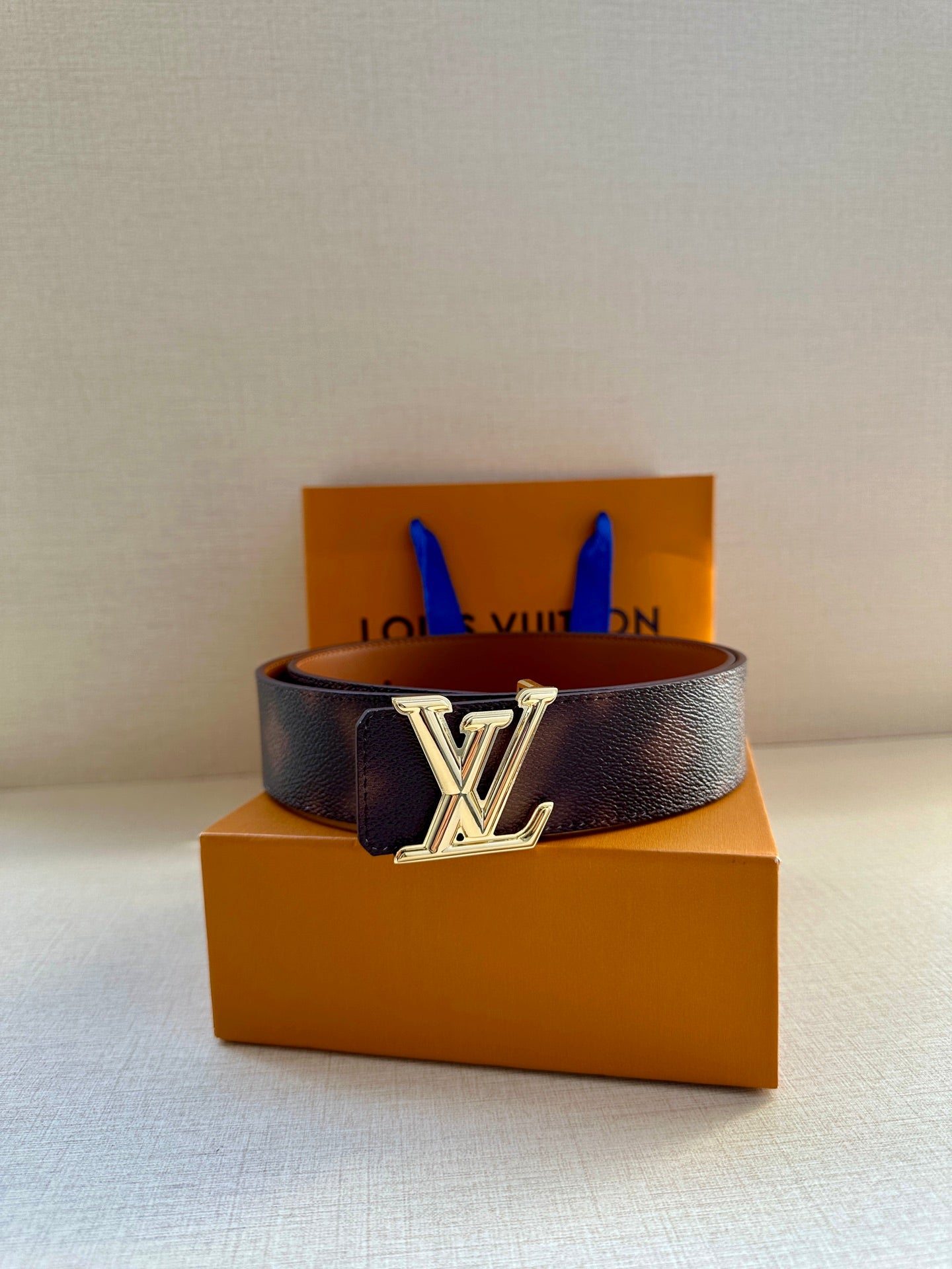 Designer belt in dark brown leather with silver-tone LV buckle and keeper holes.
