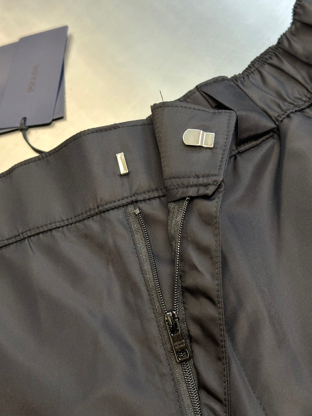 Prada nylon shorts, black, front close-up with zipper fly and adjustable belt tab