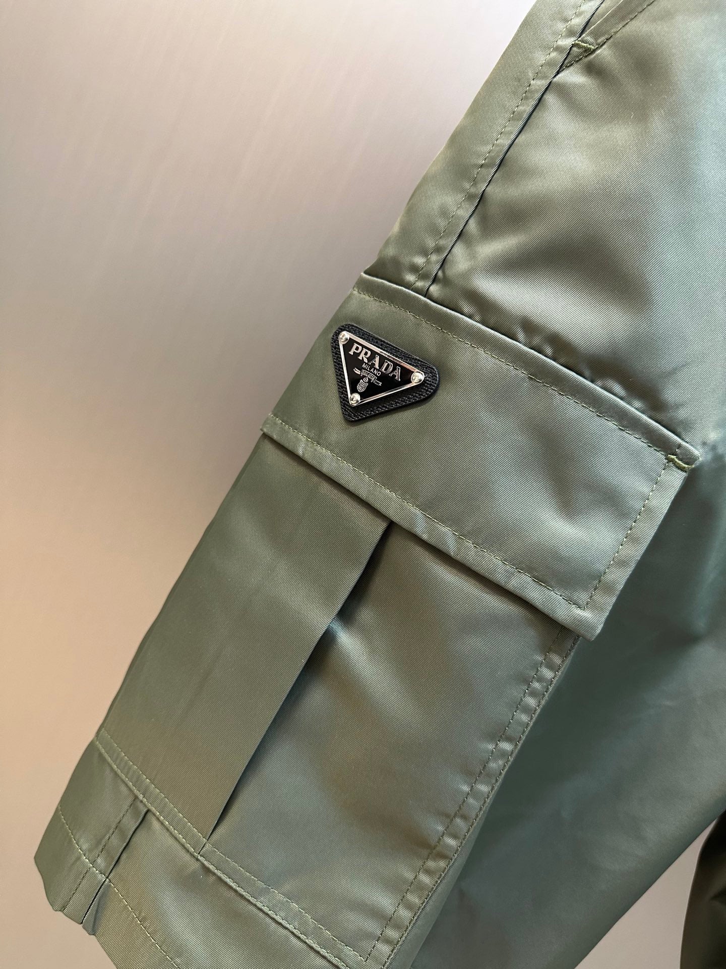 Olive cargo shorts with PRADA logo patch and flap pocket