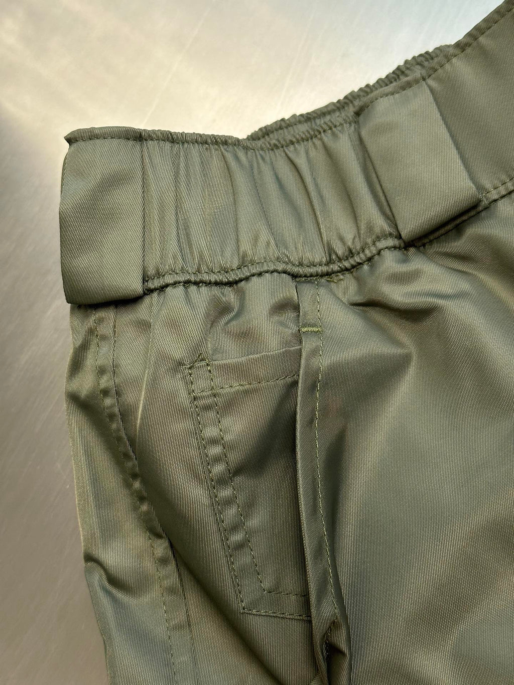 Prada cargo shorts close-up of back yoke seam and stitched pocket panel