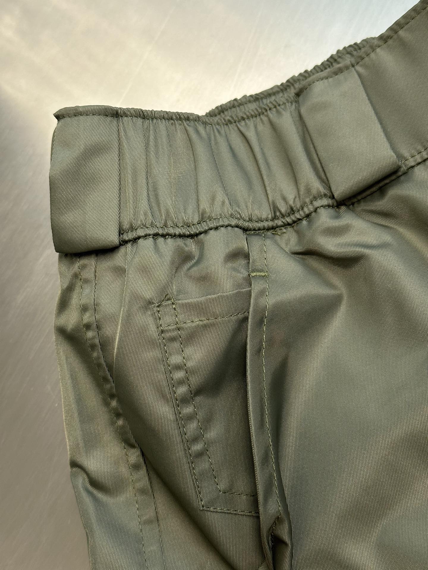 Prada cargo shorts close-up of back yoke seam and stitched pocket panel